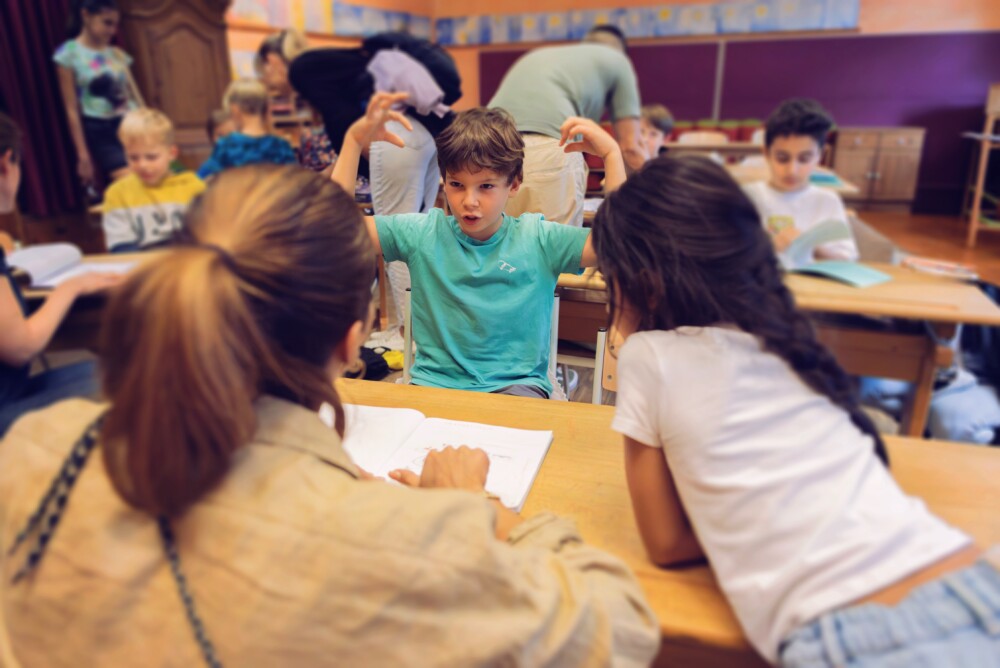 Eine Gruppe von Kindern, die an einem Tisch in einem Klassenzimmer sitzen