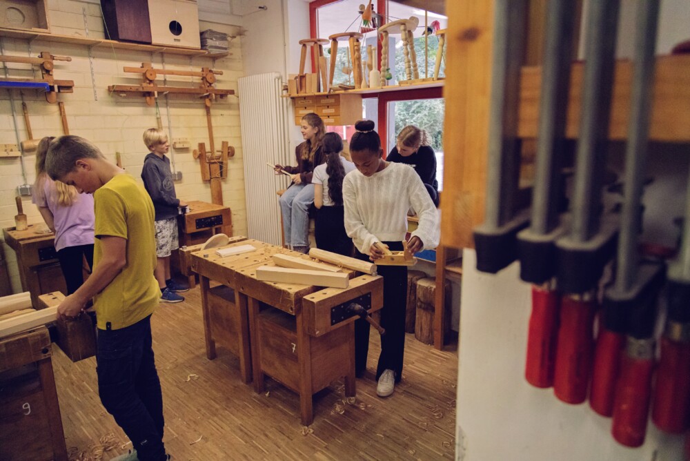 Eine Gruppe von Menschen in einem Raum mit einer Holzwerkbank