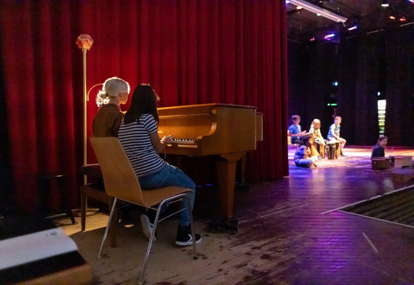 Eine Gruppe von Leuten, die auf der Bühne Klavier spielen